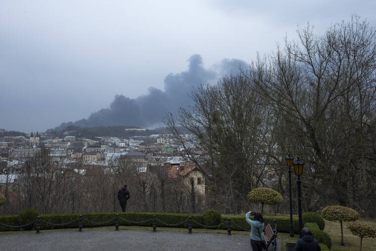 NARIMAN EL-MOFTY / AP
                                People watch the smoke at it rises the air in Lviv, western Ukraine.