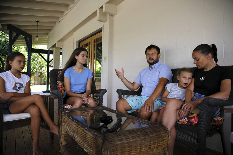 CALEB JONES VIA AP / MARCH 23
                                Vasyl Prishchak, center, of Kyiv, Ukraine, speaks to The Associated Press as his wife, Marina, right, and daughters, Ksenia, 5, second from right, Sofiia, 10, left, and Mariia, 16, second from left, listen at their temporary home in Kailua. The Prishchak family traveled to Hawaii for a long-awaited vacation on Feb. 16 and planned to return to Ukraine on March 7. But a week into their vacation, Russia invaded their country, leaving the family in shocked disbelief with no access to family, friends, money or their home.