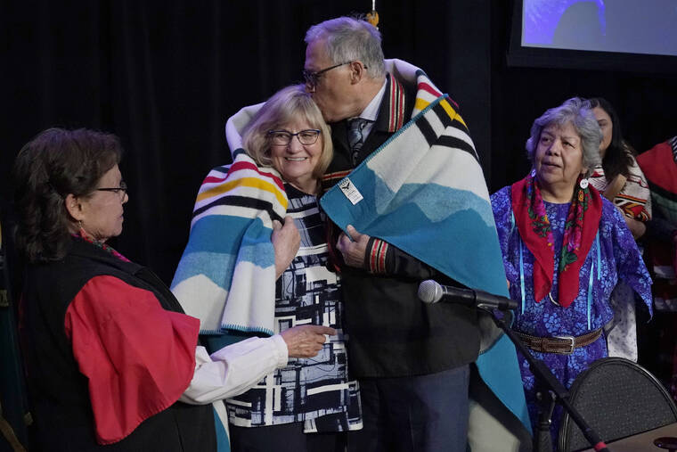ASSOCIATED PRESS
                                Washington Gov. Jay Inslee, second from right, kisses his wife Trudi, after they were presented a blanket in a ceremony after Inslee signed a bill that creates a first-in-the-nation statewide alert system for missing Indigenous people — particularly women, today, in Quil Ceda Village, near Marysville, Wash., north of Seattle. The law creates a system similar to Amber Alerts, which are used for missing children in many states.