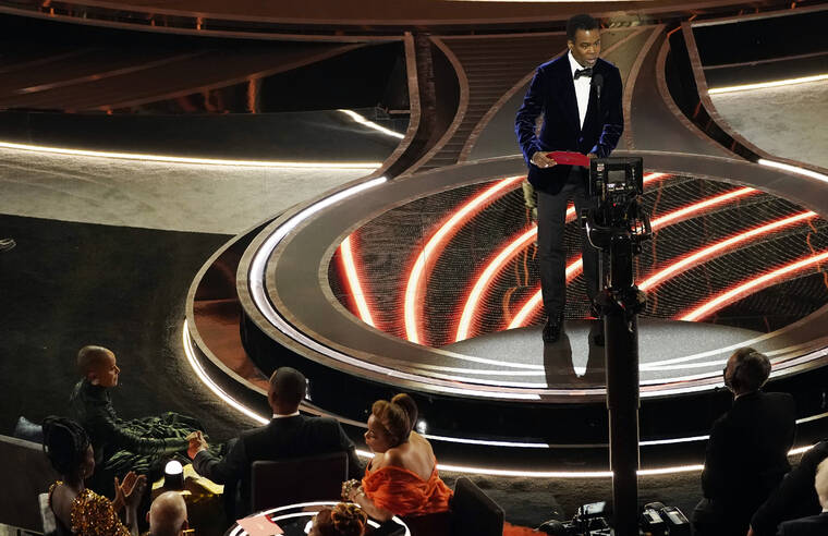ASSOCIATED PRESS / MARCH 27
                                Presenter Chris Rock, right, speaks onstage as Jada Pinkett Smith and Will Smith, bottom left, look on after Smith went onstage and slapped Rock at the Oscars at the Dolby Theatre in Los Angeles.