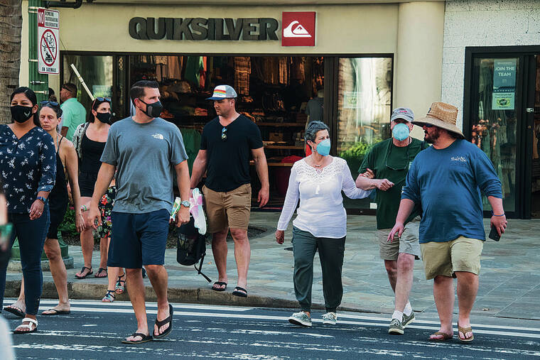 CRAIG T. KOJIMA / CKOJIMA@STARADVERTISER.COM
                                Masked and unmasked pedestrians walked in Waikiki on March 1.