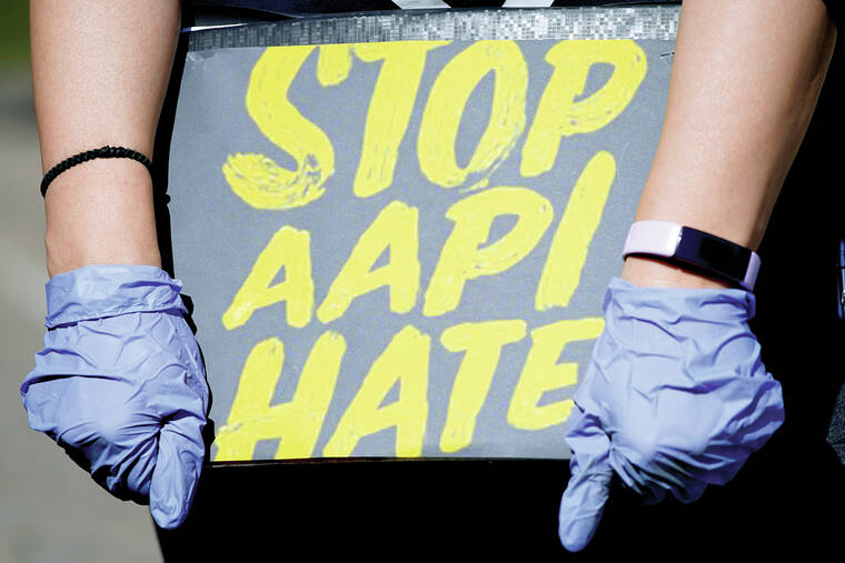 ASSOCIATED PRESS / MARCH 20
                                In this March 20, 2021, file photo, woman holds a sign and attends a rally to support stop AAPI (Asian Americans and Pacific Islanders) hate at the Logan Square Monument in Chicago.