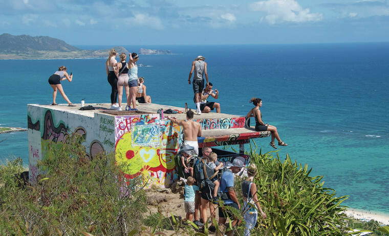 CRAIG T. KOJIMA / CKOJIMA@STARADVERTISER.COM
                                The state Department of Land and Natural Resources is working to fix erosion at the Lanikai Pillbox Trail and limit the number of hikers. Above, people stand on the trail’s structure to enjoy the breathtaking view.