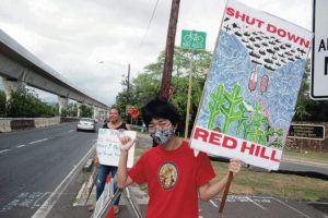 CRAIG T. KOJIMA / CKOJIMA@STARADVERTISER.COM
                                Kody Kimoto was among a group holding signs at Pearl Harbor’s Halawa Gate on Monday after the Defense Department announced it would shut down the Red Hill Bulk Fuel Storage Facility.