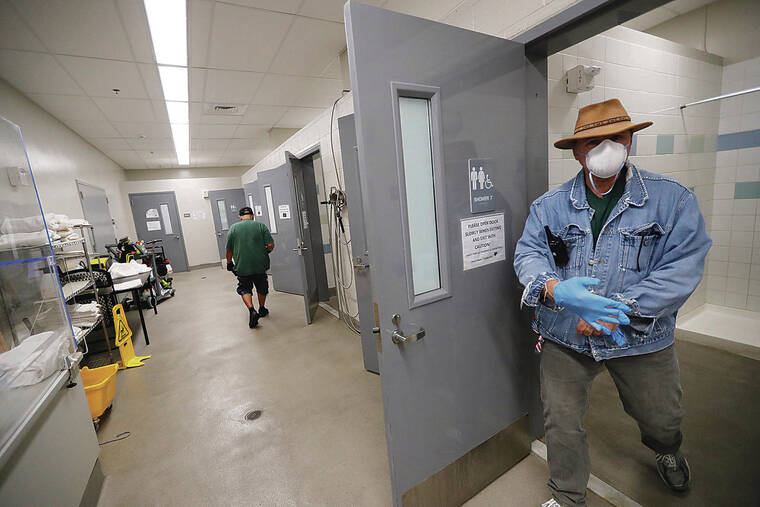 JAMM AQUINO / JAQUINO@STARADVERTISER.COM
                                Center assistant Jeffrey Nunes, above, walks out of one of the restrooms at the Punawai Rest Stop in Iwilei, which provides showers, laundry and mail services for the homeless.