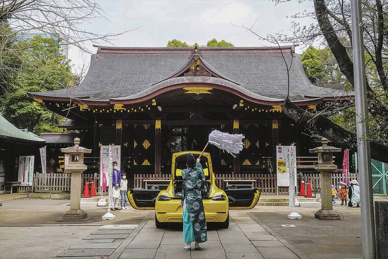 ASSOCIATED PRESS
                                <strong>Honk if you’ve been </strong><strong>blessed</strong>: A Shinto priest blesses a car for traffic safety as the owner of the automobile visits a shrine March 30 in Tokyo.