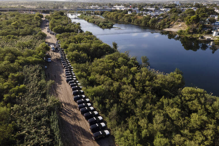 ASSOCIATED PRESS
                                A line of Texas Department of Safety vehicles lined up on the Texas side of the Rio Grande with Mexico visible, right, near an encampment of migrants, many from Haiti, Sept. 22, in Del Rio, Texas. Former Trump administration officials are pressing Republican border governors to declare an “invasion” along the U.S.-Mexico border.