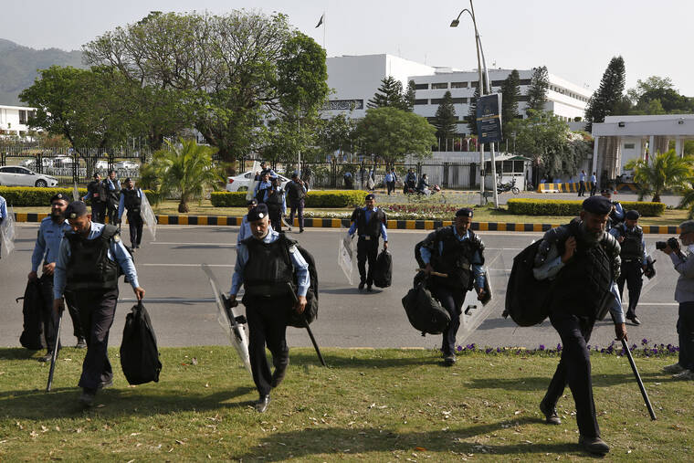 ANJUM NAVEED / AP
                                Police officers with riot gears arrive to take position outside the National Assembly, in Islamabad, Pakistan, Saturday.