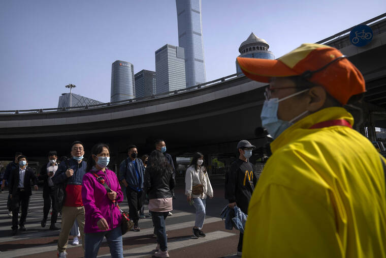MARK SCHIEFELBEIN / AP
                                Commuters wearing face masks walk across an intersection in the central business district in Beijing, Tuesday.