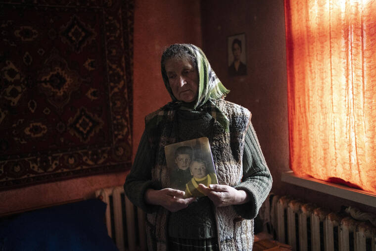 ASSOCIATED PRESS / APRIL 14
                                Nadiya Trubchaninova, 70, stands in her bedroom holding a portrait of her sons Oleg Trubchaninov, 46, and Vadym, 48, who was killed by Russian soldiers last March 30 in Bucha, in the outskirts of Kyiv, Ukraine.