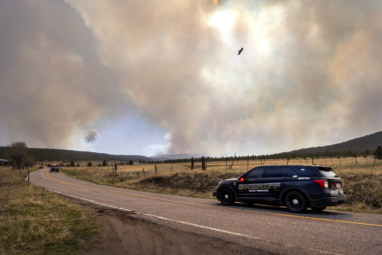 ASSOCIATED PRESS
                                San Miguel County Sheriff’s Officers patrol N.M. 94 near Penasco Blanco, N.M. as the Calf Fire burns on Friday.Destructive Southwest fires have burned dozens of homes in northern Arizona and put numerous small villages in New Mexico in the path of danger, as wind-fueled flames chewed up wide swaths of tinder dry forest and grassland and towering plumes of smoke filled the sky.