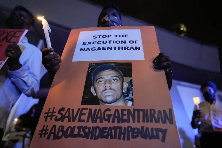 VINCENT THIAN / AP
                                Activists hold posters against the impending execution of Nagaenthran K. Dharmalingam, sentenced to death for trafficking heroin into Singapore, during a candlelight vigil gathering outside the Singaporean Embassy in Kuala Lumpur, Malaysia.
