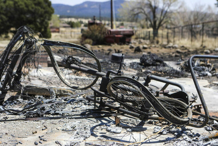 ARIZONA DAILY SUN / AP / APRIL 25
                                The burned and twisted frame of a bicycle that once belonged to Trisha Peralta lies in the rubble of a burned shed on her family’s property after the Tunnel Fire destroyed the property, including the house, the week before.
