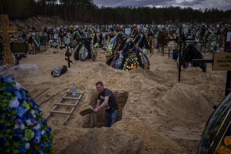ASSOCIATED PRESS
                                Gravedigger Alexander, dug a grave at the cemetery of Irpin, on the outskirts of Kyiv, today.