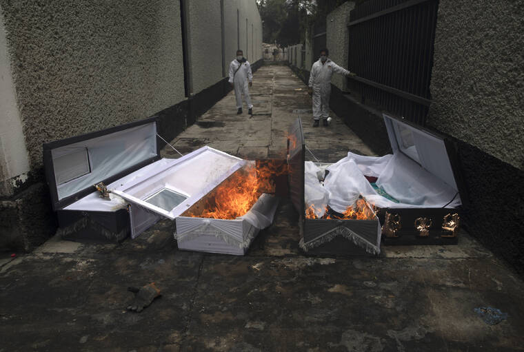 ASSOCIATED PRESS / 2020
                                Crematorium workers burn the coffins of COVID-19 victims after they have been cremated at the San Nicolas Tolentino cemetery in the Iztapalapa neighborhood of Mexico City.