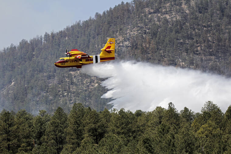 U.S. FOREST SERVICE / AP
                                An aircraft known as a “super scooper” battles the Hermits Peak and Calf Canyon Fires in the Santa Fe National Forest in New Mexico.