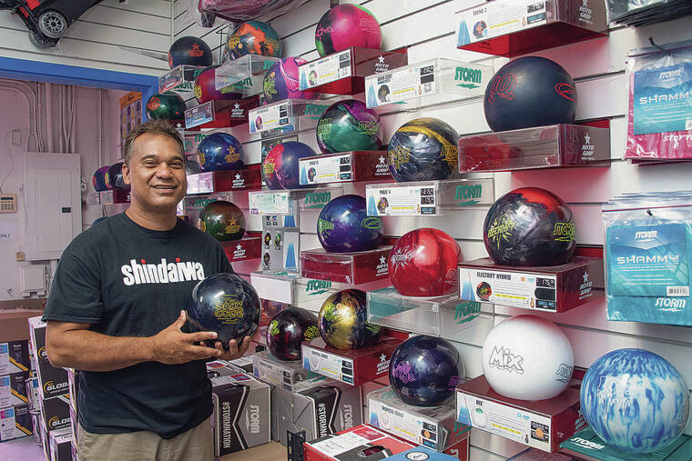 CRAIG T. KOJIMA / CKOJIMA@STARADVERTISER.COM
                                Terrence Fernandez stands next to a display of bowling balls.