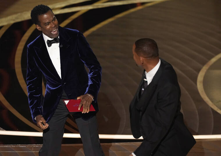 INVISION / AP
                                Presenter Chris Rock, left, reacts after being hit on stage by Will Smith at the Oscars on Sunday.