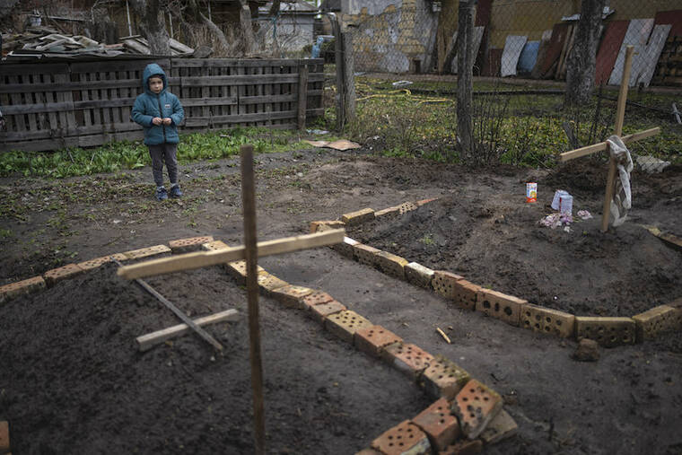ASSOCIATED PRESS / APRIL 4
                                In the courtyard of their house, Vlad Tanyuk, 6, looks at the grave of his mother Ira Tanyuk, who died because of starvation and stress due to the war, in Bucha, on the outskirts of Kyiv, Ukraine. Russia is facing a fresh wave of condemnation after evidence emerged of what appeared to be deliberate killings of dozens if not hundreds of civilians in Ukraine.
