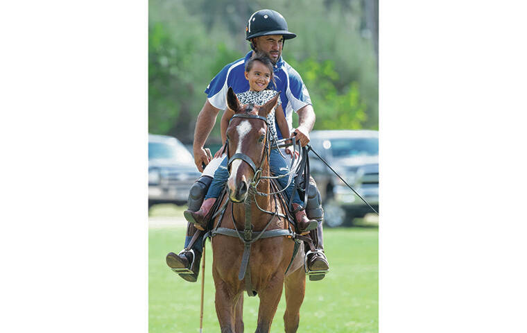 CRAIG T. KOJIMA / CKOJIMA@STARADVERTISER.COM
                                Alia Kaaialii gets a ride with her father, Levi Rita, before a polo match begins.