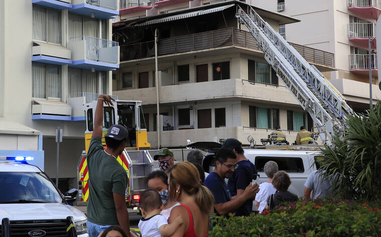 JAMM AQUINO / JAQUINO@STARADVERTISER.COM
                                People wait at a safe distance as firefighters work to contain a structure fire at an apartment complex on Nohonani Street,
