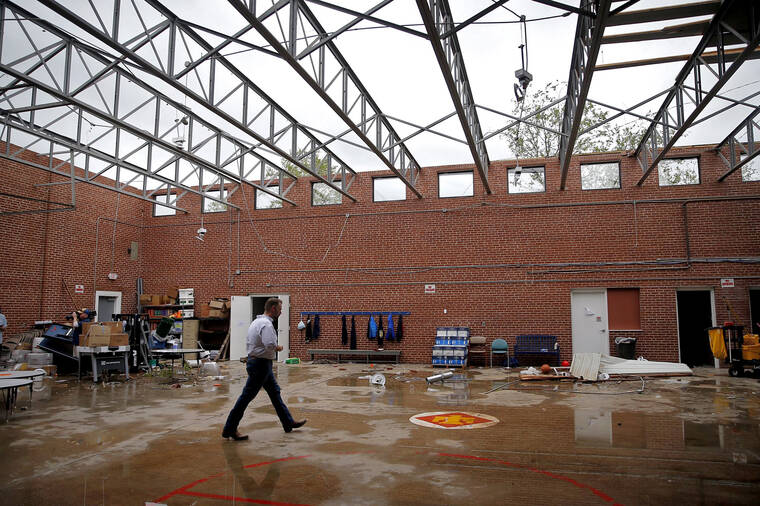 THE OKLAHOMAN / AP
                                Paul Campbell, Founder of the academy of Seminole, walks through the damage caused by a tornado to the school building in Seminole, Okla. .