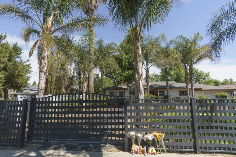 ASSOCIATED PRESS
Flowers and teddy bears are left outside a ranch-style house in the West Hills neighborhood of the San Fernando Valley in Los Angeles. Police say three children were found dead at this Los Angeles home over the weekend and their mother and a teenager were arrested in the killings.