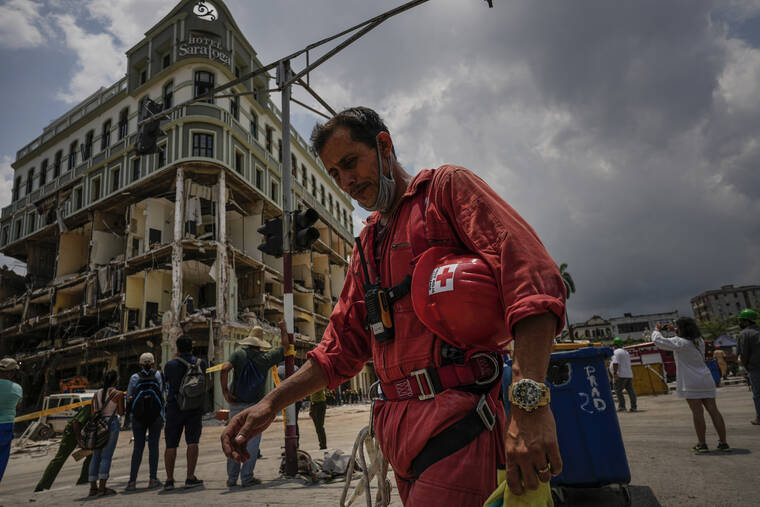 ASSOCIATED PRESS
                                A member of the Cuban Red Cross takes a break after working in the rubble at the site of a deadly explosion that destroyed the five-star Hotel Saratoga in Old Havana, Cuba.