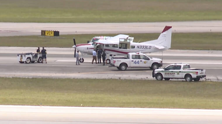 WPTV VIA ASSOCIATED PRESS
                                Emergency personnel surrounding a Cessna plane at Palm Beach International Airport, Tuesday, in West Palm Beach, Fla. A passenger with no flying experience was able to land the plane safely with help of air traffic controllers after the pilot was too sick to handle the controls.