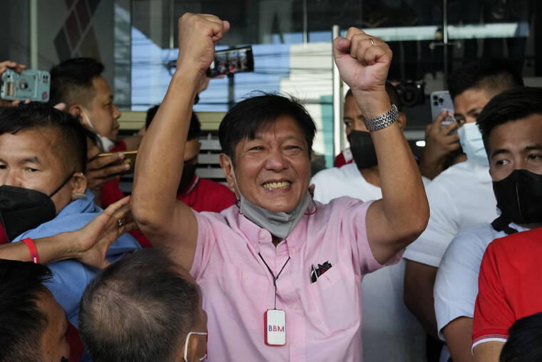 AARON FAVILA / AP
                                Presidential candidate Ferdinand “Bongbong” Marcos Jr. celebrates outside his headquarters in Mandaluyong, Philippines on Wednesday.