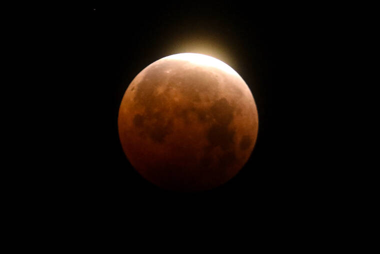 ASSOCIATED PRESS
                                Light shined from a total lunar eclipse over Santa Monica Beach in Santa Monica, Calif., Wednesday, in May 26. A total lunar eclipse will grace the night skies this weekend, providing longer than usual thrills for stargazers across North and South America.