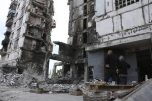 ASSOCIATED PRESS
                                Local residents stand at the side of damaged during a heavy fighting buildings in Mariupol in eastern Ukraine.