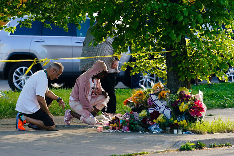 People pay their respects outside the scene of a shooting at a supermarket in Buffalo, N.Y., Sunday, May 15, 2022. (AP Photo/Matt Rourke)