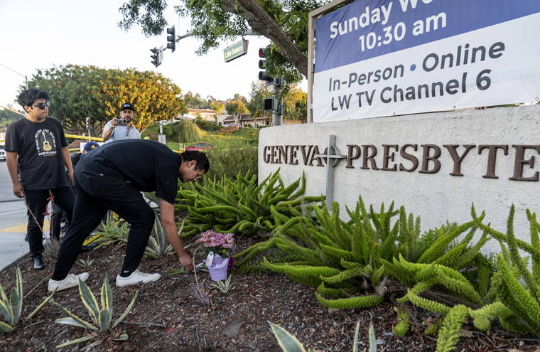 ASSOCIATED PRESS
                                Hector Gomez, left, and Jordi Poblete, worship leaders at the Mariners Church Irvine, leave flowers outside the Geneva Presbyterian Church in Laguna Woods, Calif., Sunday after a fatal shooting.