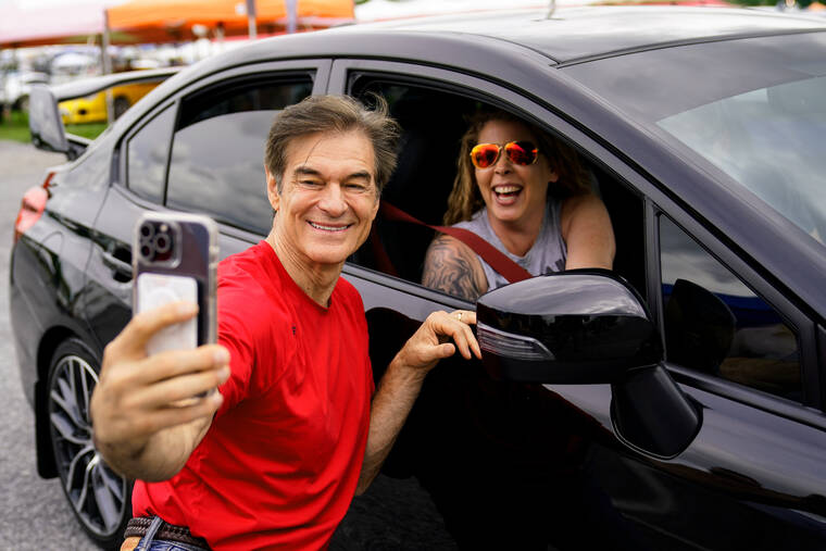 ASSOCIATED PRESS
                                Mehmet Oz, a Republican candidate for U.S. Senate in Pennsylvania, poses for a photograph with an attendee during his visit to a car show in Carlisle, Pa., Saturday.