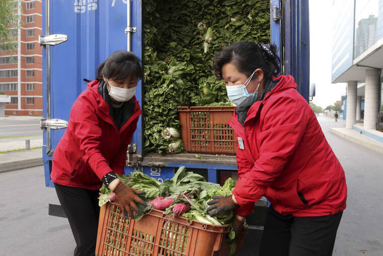 JON CHOL JIM / ASSOCIATED PRESS
                                Employees of a greengrocery in Mirae Scientists Street carry cabbages to supply to residents staying home as the state increased measures to stop the spread of illness in Pyongyang, North Korea today.