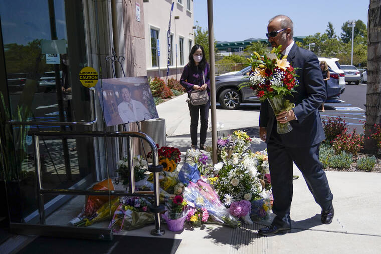 ASSOCIATED PRESS
                                A man placed flowers at a memorial honoring Dr. John Cheng that sat outside his office building, today, in Aliso Viejo, Calif. Cheng, 52, was killed in Sunday’s shooting at Geneva Presbyterian Church.