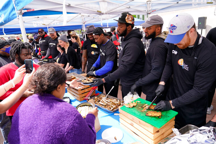 ASSOCIATED PRESS
                                Buffalo Bills players serve food at a World Central Kitchen tent near the scene of Saturday’s shooting at a supermarket, in Buffalo, N.Y.