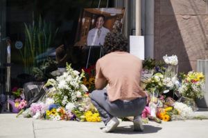 ASSOCIATED PRESS / MAY 17
                                Gabe Kipers, a neighbor of shooting victim Dr. John Cheng, kneels at a memorial for him outside his office building in Aliso Viejo, Calif.