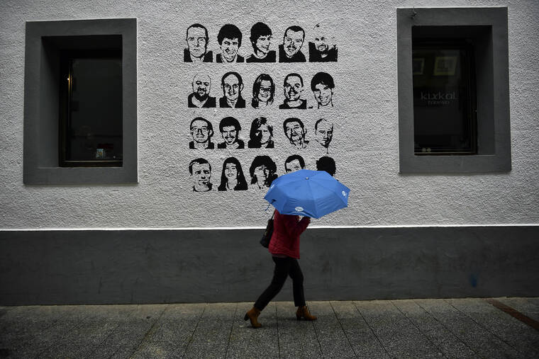 ALVARO BARRIENTOS VIA AP / 2018
                                A woman shelters from the rain under an umbrella, while walking past a wall painted with portraits of prisoners of the Basque separatist armed group ETA, in the small village of Hernani, northern Spain. The United States is poised to remove five extremist groups, all believed to be defunct, from its list of foreign terrorist organizations. Several of these groups once posed significant threats, killing hundreds if not thousands of people across Asia, Europe and the Middle East. The organizations include the Basque separatist group ETA , the Japanese cult Aum Shinrikyo, the radical Jewish group Kahane Kach and two Islamic groups that have been active in Israel, the Palestinian territories and Egypt.