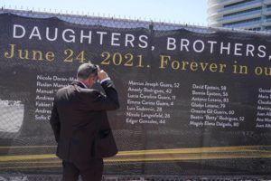ASSOCIATED PRESS / MAY 12
                                Pablo Langesfeld looks at the name of his daughter Nicole Langesfeld in Surfside, Fla. A large banner with the names of the 98 killed in the collapse of the Champlain Towers South building nearly a year ago, was installed around the site.