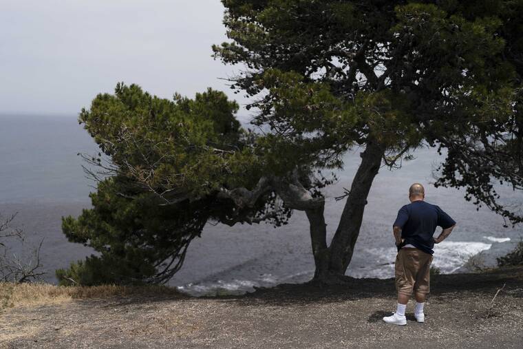 ASSOCIATED PRESS
                                An onlooker stood near an ocean cliff in Palos Verdes Estates, Calif., today. Four people fell off a Southern California ocean cliff in the early morning darkness today and a man was killed and two women were critically injured, authorities said.