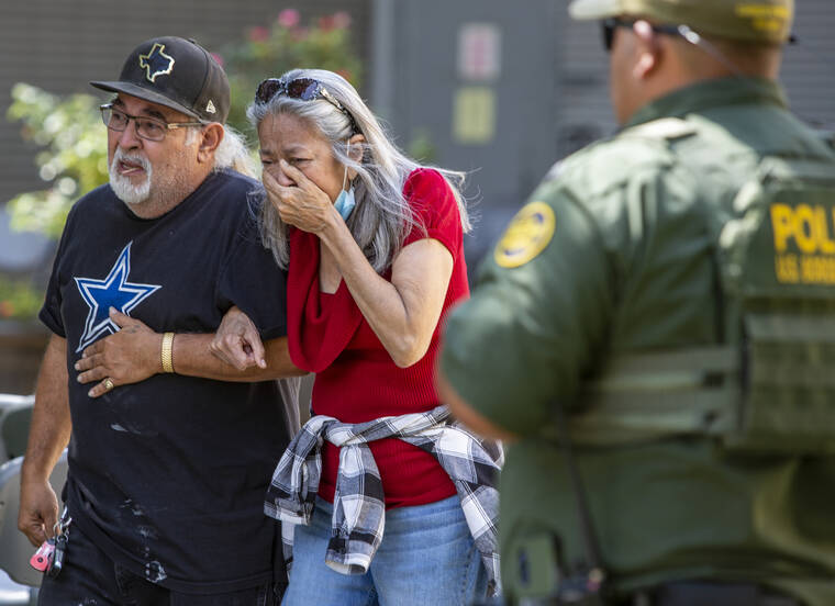 THE SAN ANTONIO EXPRESS-NEWS / AP
                                A woman cries as she leaves the Uvalde Civic Center in Uvalde, Texas.