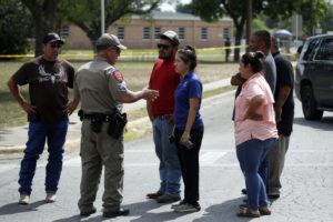 ASSOCIATED PRESS
                                A policeman talks to people asking for information outside of the Robb Elementary School in Uvalde, Texas, today.