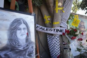 ASSOCIATED PRESS / MAY 19
                                Yellow tape marks bullet holes on a tree and a portrait and flowers create a makeshift memorial at the site where Palestinian-American Al-Jazeera journalist Shireen Abu Akleh was shot and killed in the West Bank city of Jenin.