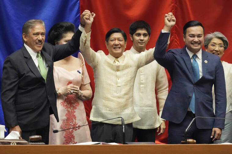 AARON FAVILA / AP
                                President-elect Ferdinand “Bongbong” Marcos Jr., center, raises hands with Senate President Vicente Sotto III, left, and House Speaker Lord Allan Velasco during his proclamation at the House of Representatives, Quezon City, Philippines.