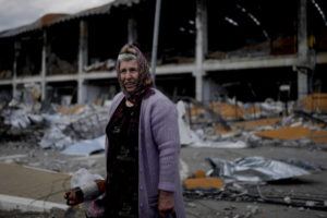 NATACHA PISARENKO / AP
                                A woman stands in front of a damage building ruined by attacks in Irpin, outskirts Kyiv, Ukraine.