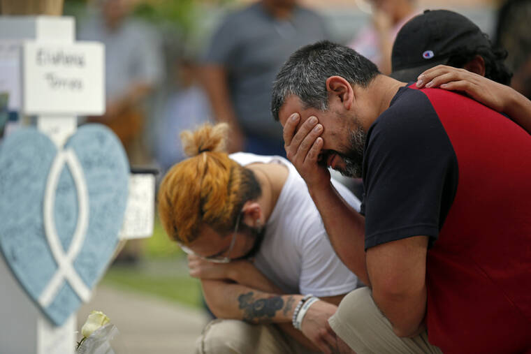 ASSOCIATED PRESS
                                Vincent Salazar, right, father of Layla Salazar, weeps while kneeling in front of a cross with his daughter’s name at a memorial site for the victims killed in this week’s elementary school shooting in Uvalde, Texas, today.