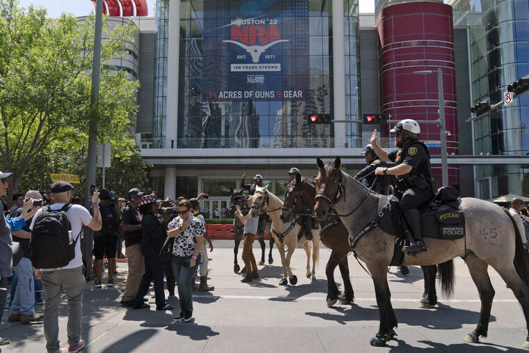 ASSOCIATED PRESS
                                Mounted police officers tell protesters to move back across the street from the National Rifle Association annual meeting at the George R. Brown Convention Center in Houston.