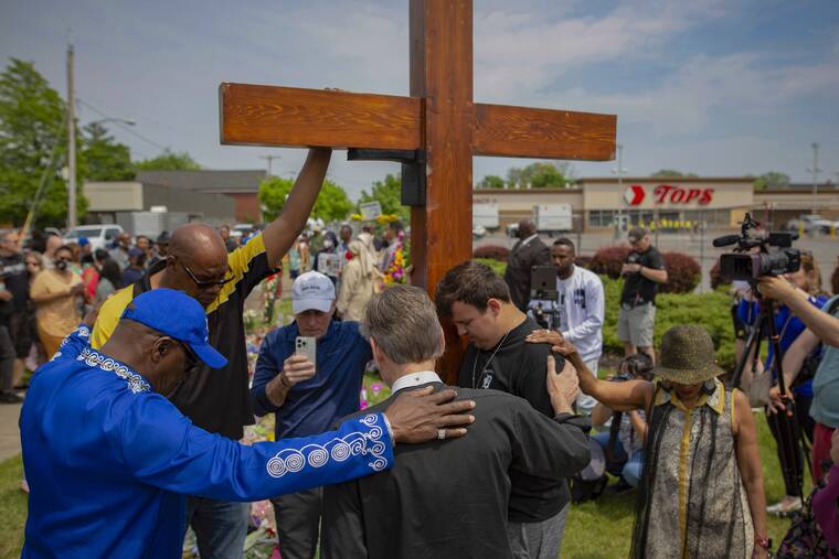 ASSOCIATED PRESS / MAY 21
                                A group prays at the site of a memorial for the victims of the Buffalo supermarket shooting outside the Tops Friendly Market in Buffalo, N.Y. Funeral services are set for Friday for three of those killed: Geraldine Talley, Andre Mackniel and Margus Morrison. They are among the 10 people killed and three wounded May 14 when a white gunman opened fire on shoppers and employees at a Tops Friendly Market.